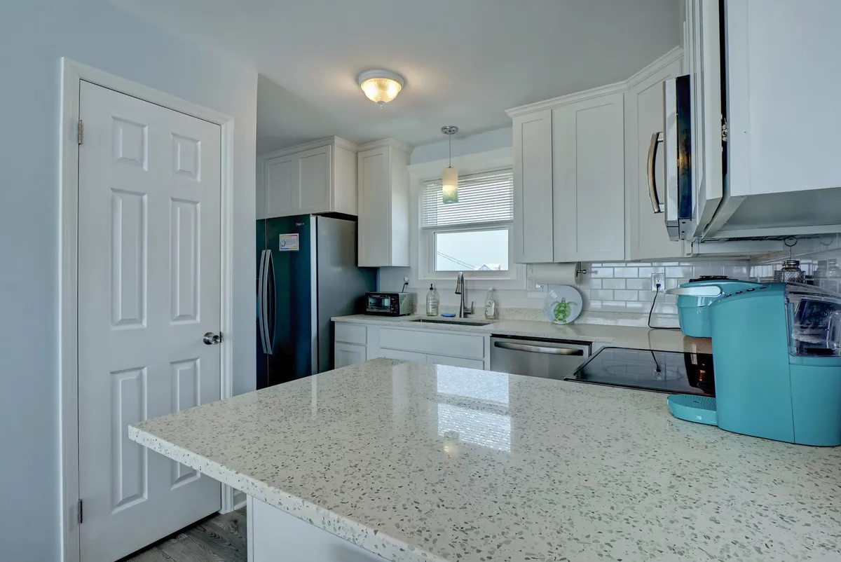 A warm and inviting kitchen featuring granite countertops, modern appliances, and a window that lets in plenty of natural light. The space is designed for cooking, with ample workspace and a welcoming layout, ideal for both preparing meals and gathering with family.