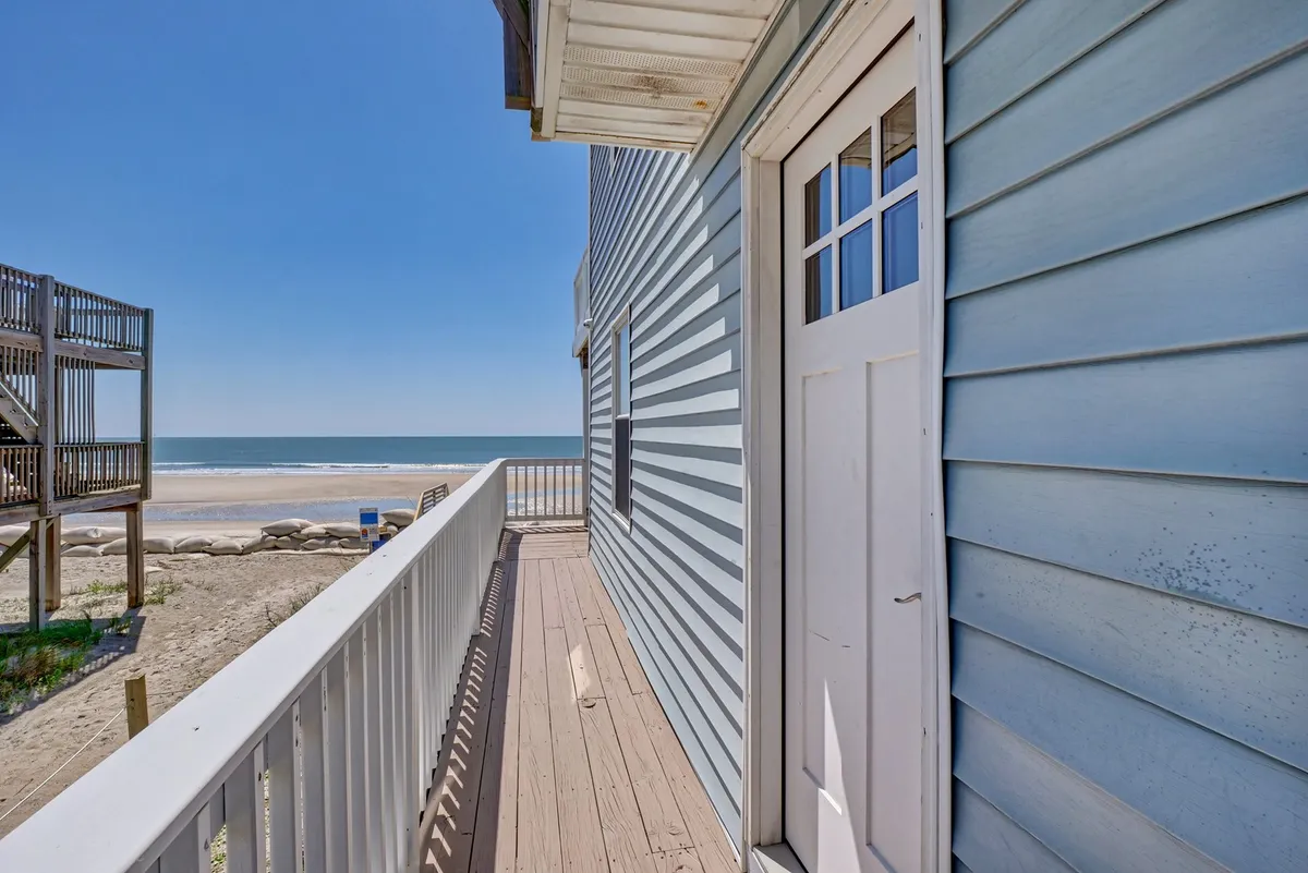 This image reveals an ocean-facing deck with a clear view of the beach, the entrance door, and a sturdy deck railing. The inviting outdoor setting is ideal for morning coffee, watching the waves, and easy access to beach strolls. The openness of the deck makes it a natural extension for both people and pets to enjoy together.